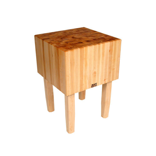 Sturdy wooden butcher block kitchen surface for food preparation and meat cutting.